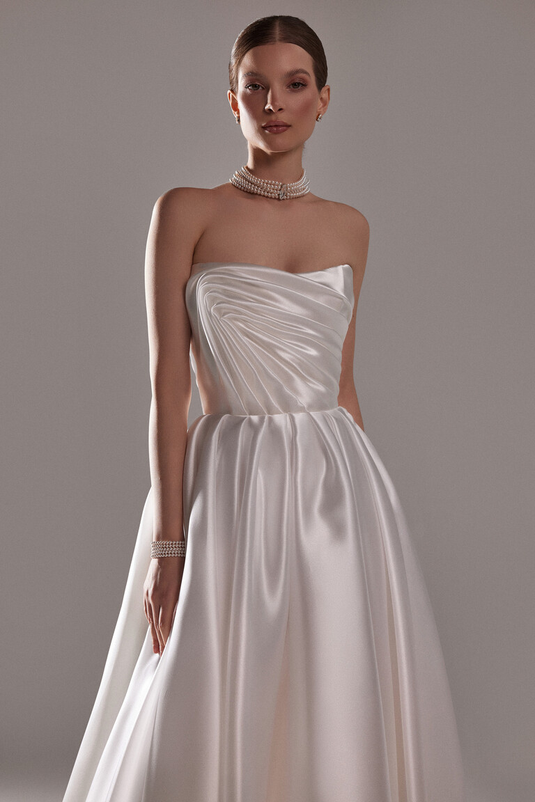 Modern Romantic Nelly Bridal Gown Silhouette Unona Nelly off-white A-line wedding dress with a straight neckline and glossy draped bodice for a modern bridal look