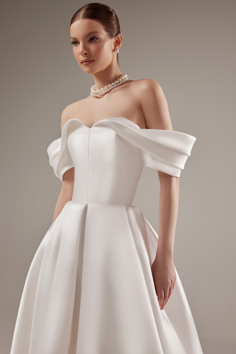 Structured Sweetheart Bodice of Fly Gown Close-up front view of the Fly wedding dress bodice showing structural Mikado fabric and off-the-shoulder draped sleeves.