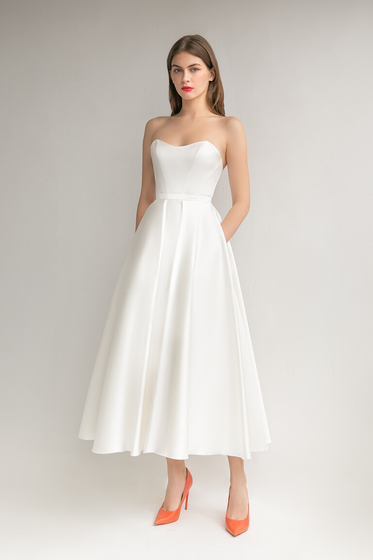 Lizzie ivory satin strapless midi dress styled with bright shoes for a modern cocktail party look.