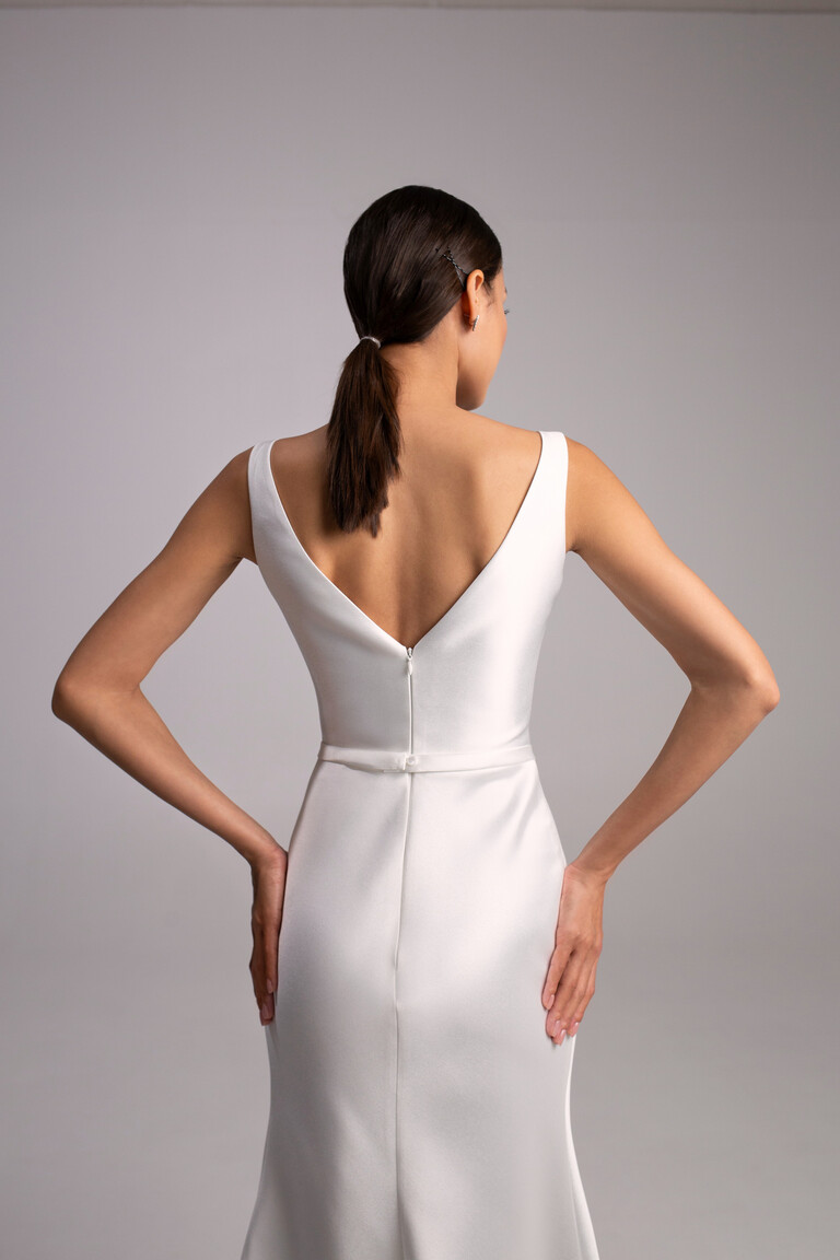 Mika Wedding Dress V-Back and Silhouette Detail Back view of Mika ivory reception dress. Elegant V-back neckline, natural waistline, and sleek mikado midi skirt.