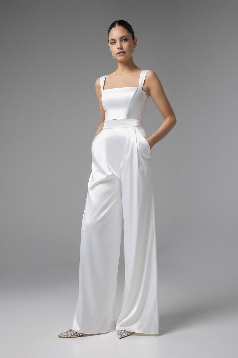 Andrea Ivory Bridal Crop Top Full Body View Modern ivory Andrea corset crop top with wide straps styled as a bridal separate with pleated wide leg trousers.