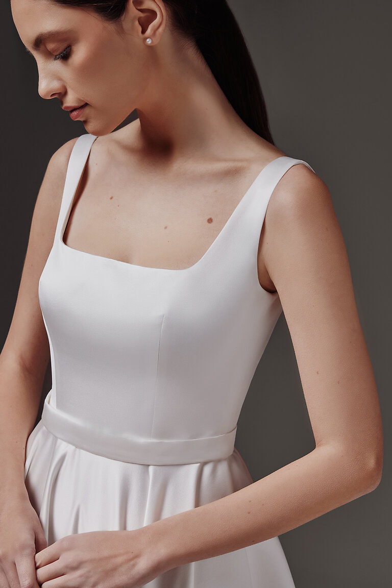 Vlada Dress Square Neckline Bodice Detail Close-up of Vlada off-white satin wedding dress bodice showing figure-defining darts and a classic square neck