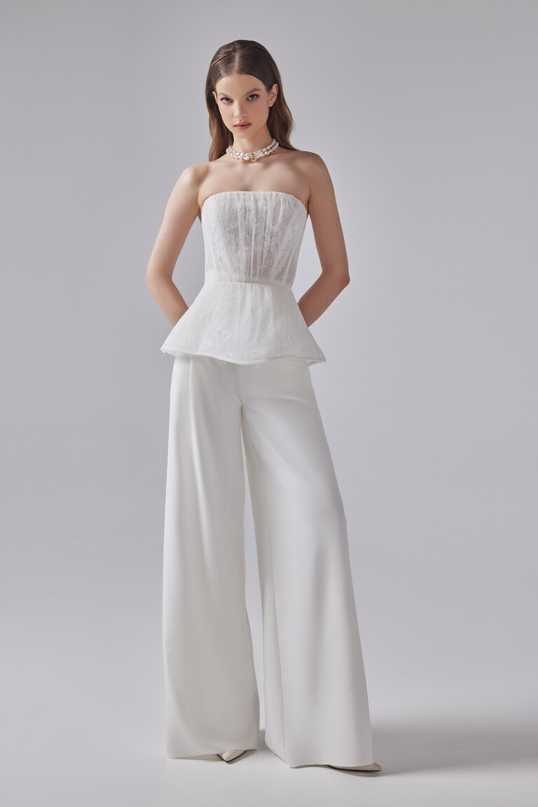 Riki off-white engagement pantsuit by Unona featuring a structured lace peplum bodice and flowing floor-length trousers