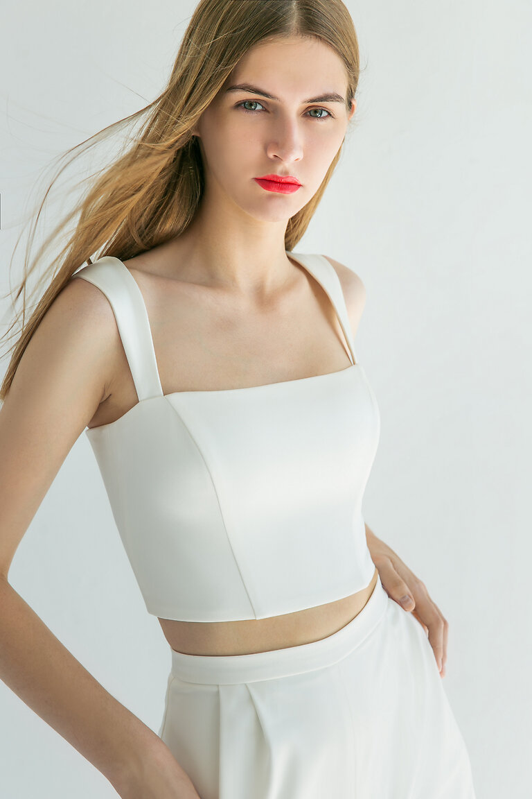 Andrea Fitted Satin Crop Top Waist Up View Waist up view of the Andrea ivory stretch satin crop top highlighting structural seams and classic square neckline detail.