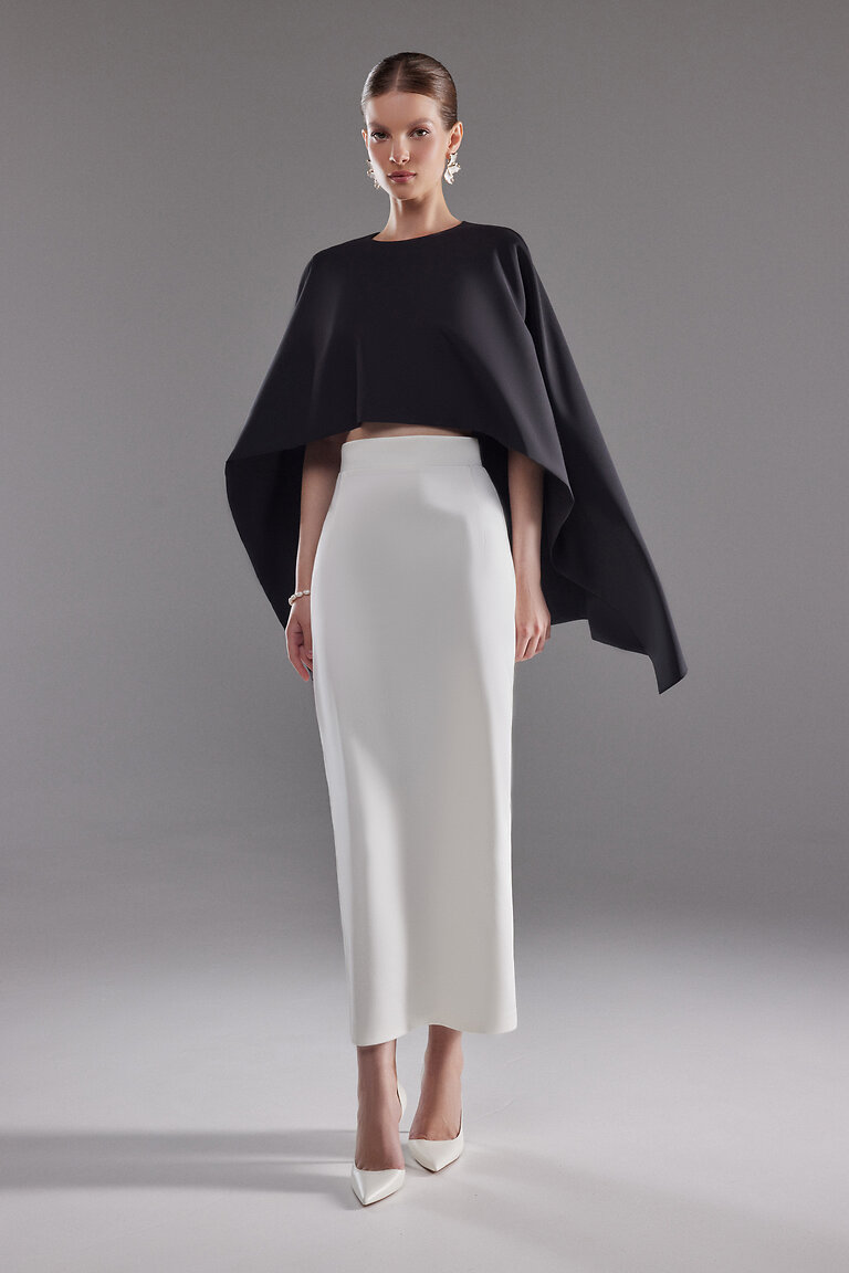 Chic Black Crepe Cape Ell Full Evening Outfit View Full length look of Unona Cape Ell. Modern black crepe cape top paired with a white maxi skirt for a formal event.