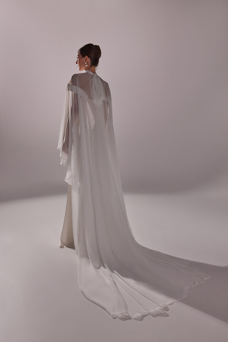 Romantic Chapel Train of Naila Bridal Cape Back view of Naila white chiffon wedding cape by Unona showing the romantic chapel train and gathered high neckline.