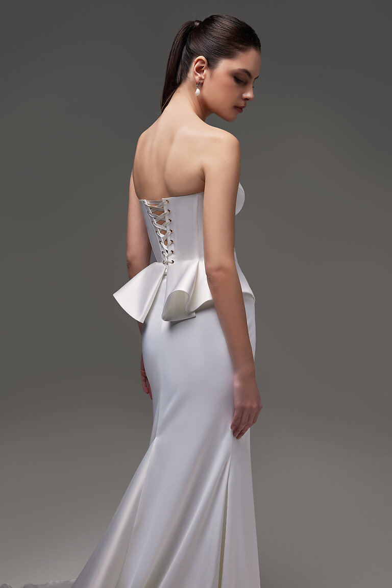 Adjustable Lace-Up Back Corset Detail Three-quarter back view of Gina ivory bridal corset highlighting the custom lace-up closure and peplum silhouette.