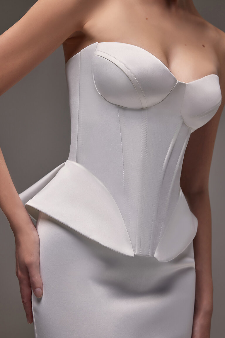 Close-Up of Gina Sweetheart Peplum Corset Close-up detail of Gina ivory satin corset showing sweetheart neckline, molded cups, and architectural peplum waist.