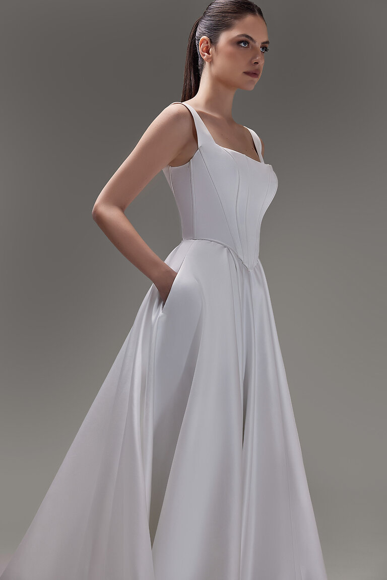 Casia Ivory Bridal Corset with a Flattering Drop Basque Waist Three-quarter view of the Unona Casia Corset. An ivory satin bridal top with a square neck and structured basque waist.