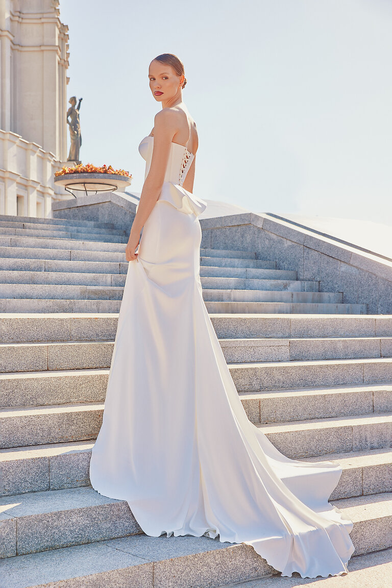 Elegant Fit and Flare Ivory Bridal Skirt Side view of the minimalist Gina bridal skirt. Ivory stretch satin hugs the hips before flaring into a beautiful train.