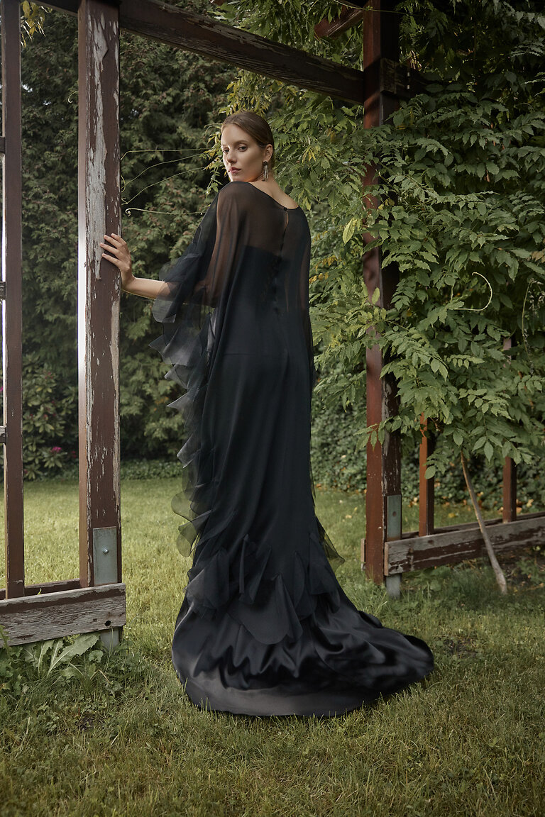 Ditta Black Gown with Dramatic Sheer Overlay Back view of Ditta black mermaid evening gown by Unona paired with a cascading sheer ruffle cape overlay.