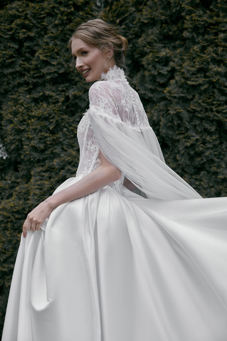 Lace High Neck Wedding Cape Button Details Side back view of off-white Evelyn wedding cape showcasing high lace neckline and delicate button closure.