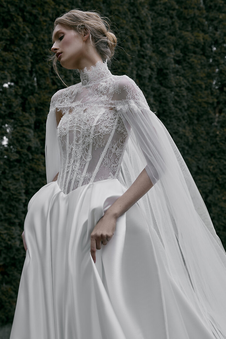 Graceful Tulle Bridal Cape Front View Front angled view of Evelyn off-white tulle cape with lace detailing draping gracefully over the shoulders.