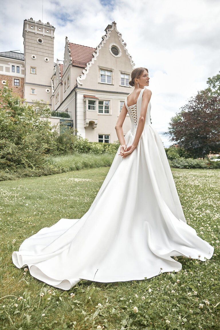 Elegant Corset Lace-Up Back of Marine Wedding Dress Back view of the Marine ivory wedding dress showcasing the traditional corset lace-up back and sweeping chapel train.