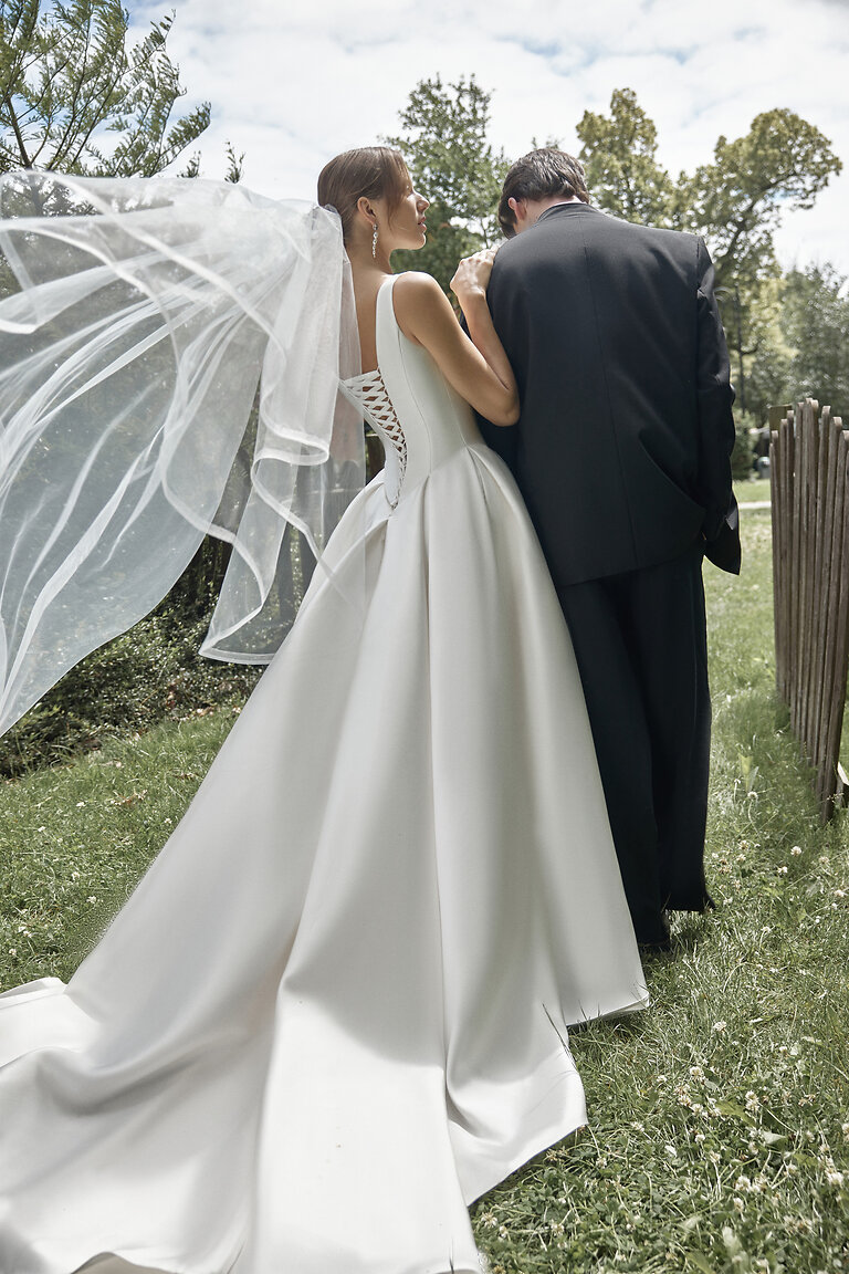 Marine Ivory Mikado Gown with Chapel Train Bride in the Marine ivory mikado A-line gown showing the elegant corset back and voluminous skirt with chapel train.