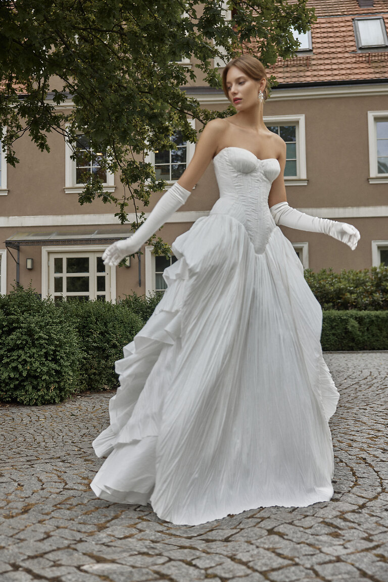 Nerina A-Line Bridal Gown with Dramatic Skirt Full body view of Unona Nerina off-white taffeta bridal gown highlighting the drop waist and voluminous tiered skirt.