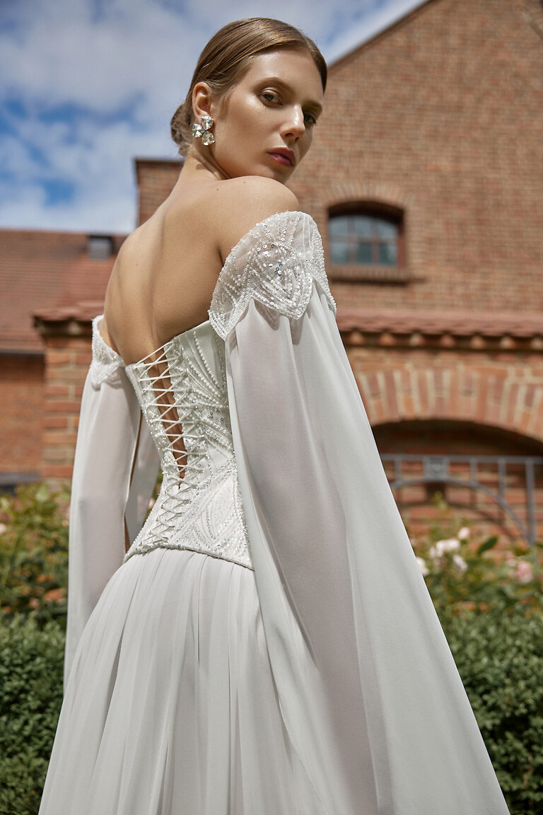 Stunning Lace-Up Corset Back Bridal Dress Back view of Leona ivory wedding dress highlighting lace-up corset back and off-the-shoulder draped sleeves