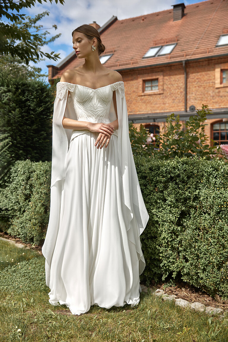 Romantic Ivory Bridal Gown with Cape Sleeves Unona Leona romantic A-line wedding dress featuring basque waist beaded corset and long chiffon cape sleeves
