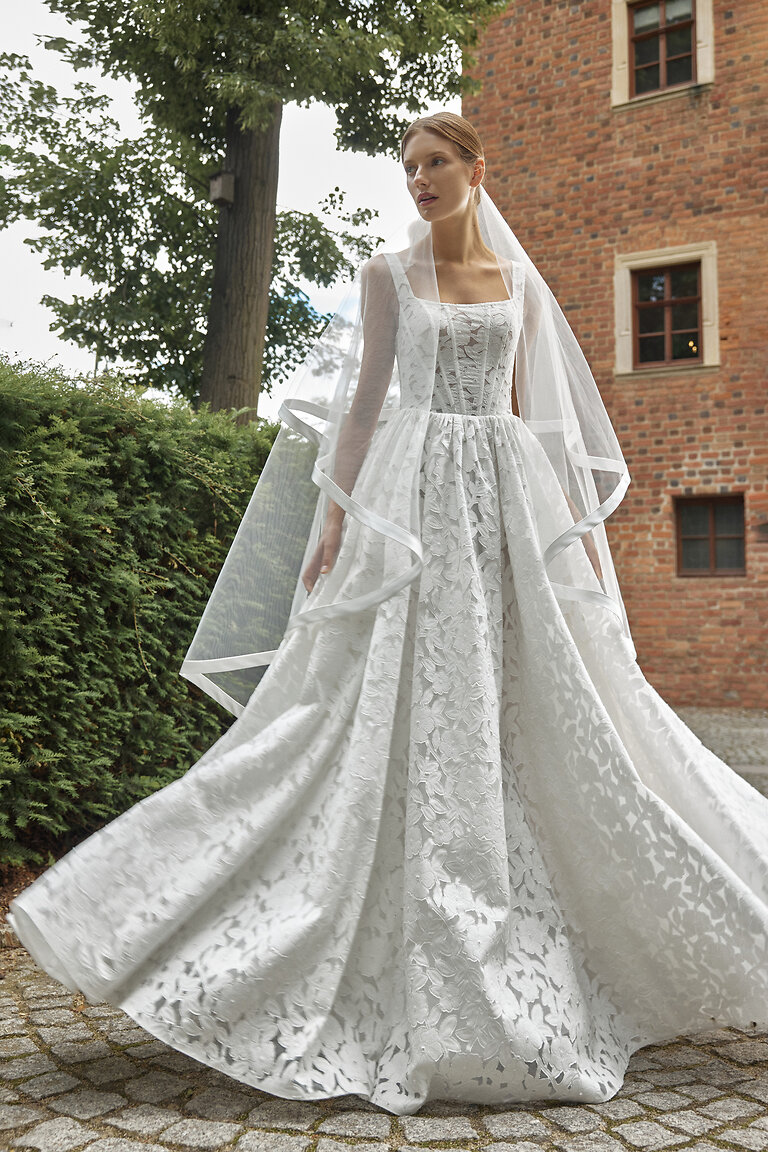 Timeless Romantic Wedding Dress with Cascading Veil Full-length view of Ruta off-white wedding gown and sheer veil on outdoor cobblestone pathway