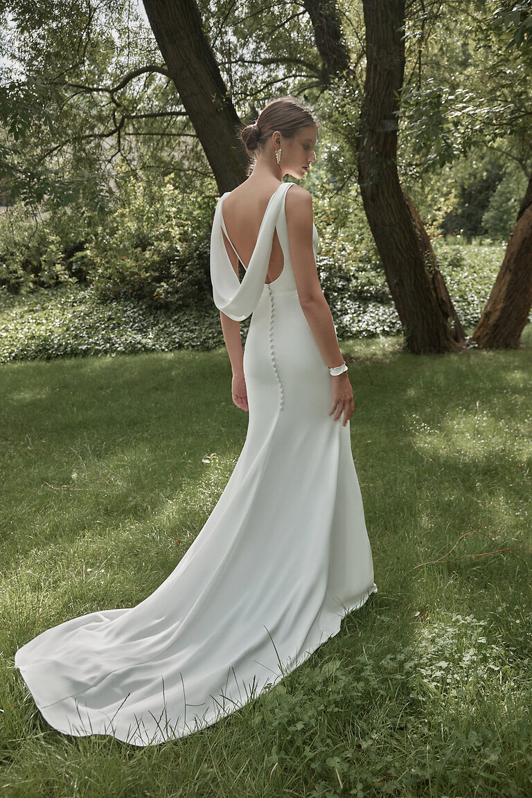 Paola ivory mermaid bridal gown showing open cowl back, covered buttons and long train